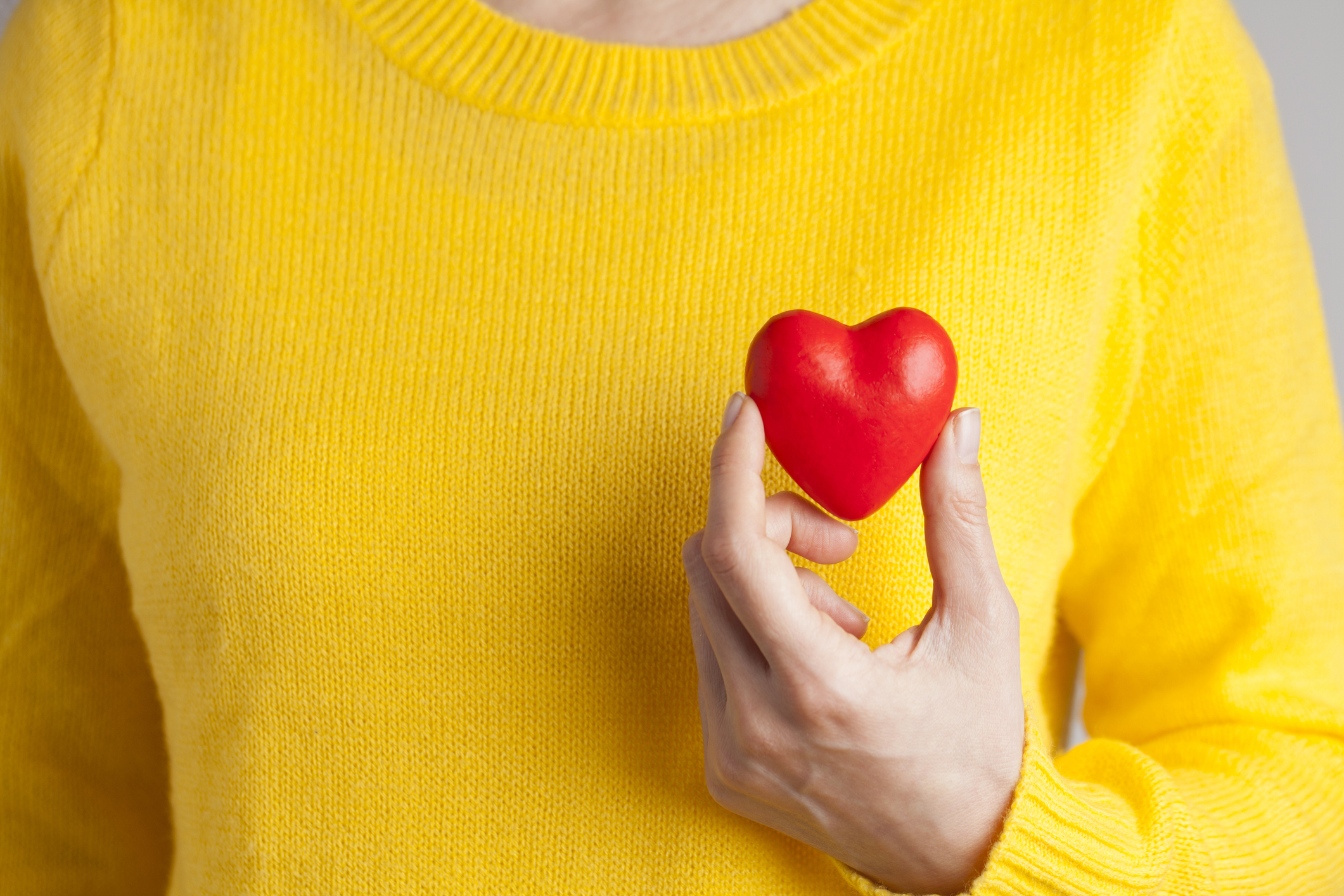 Young woman holding red heart, health insurance, donation, love concept