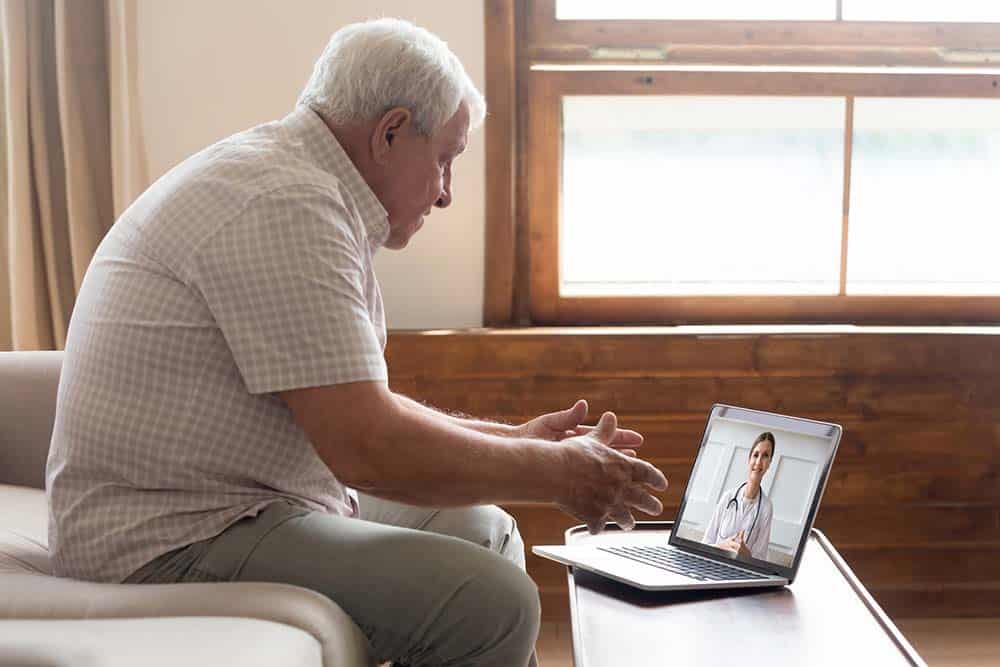 Elderly man make distant video call communicating with doctor online